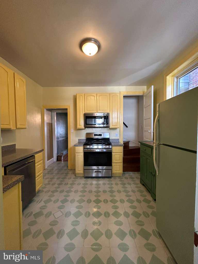 4747 Sansom Street Philadelphia, PA 19139 - Photo 12 of 21 a kitchen with a refrigerator and a stove