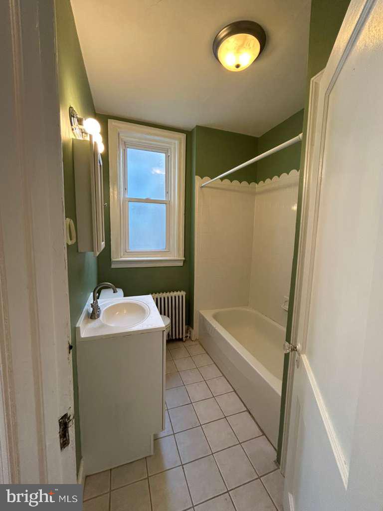 4747 Sansom Street Philadelphia, PA 19139 - Photo 15 of 21 a bathroom with a sink mirror vanity and bathtub