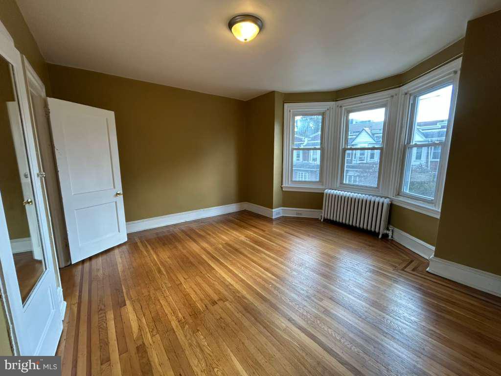 4747 Sansom Street Philadelphia, PA 19139 - Photo 18 of 21 an empty room with wooden floor and windows