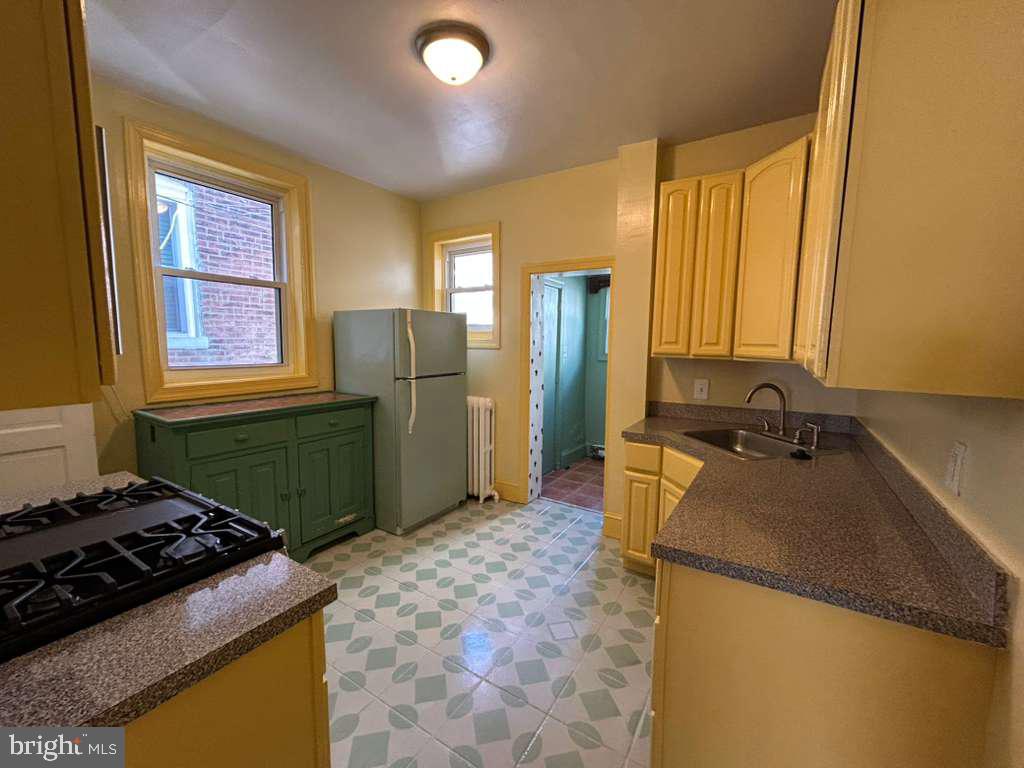 4747 Sansom Street Philadelphia, PA 19139 - Photo 8 of 21 a kitchen with a stove a refrigerator and a sink