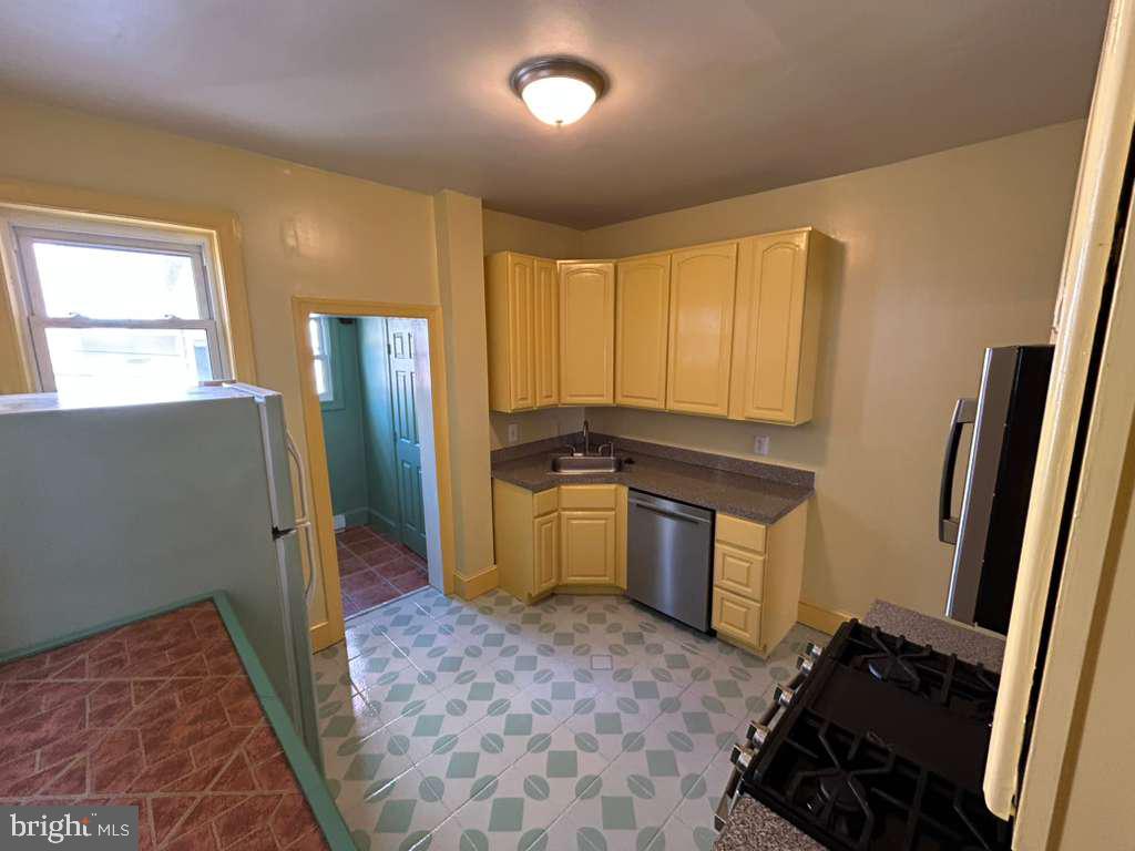 4747 Sansom Street Philadelphia, PA 19139 - Photo 9 of 21 a kitchen with a refrigerator and a stove