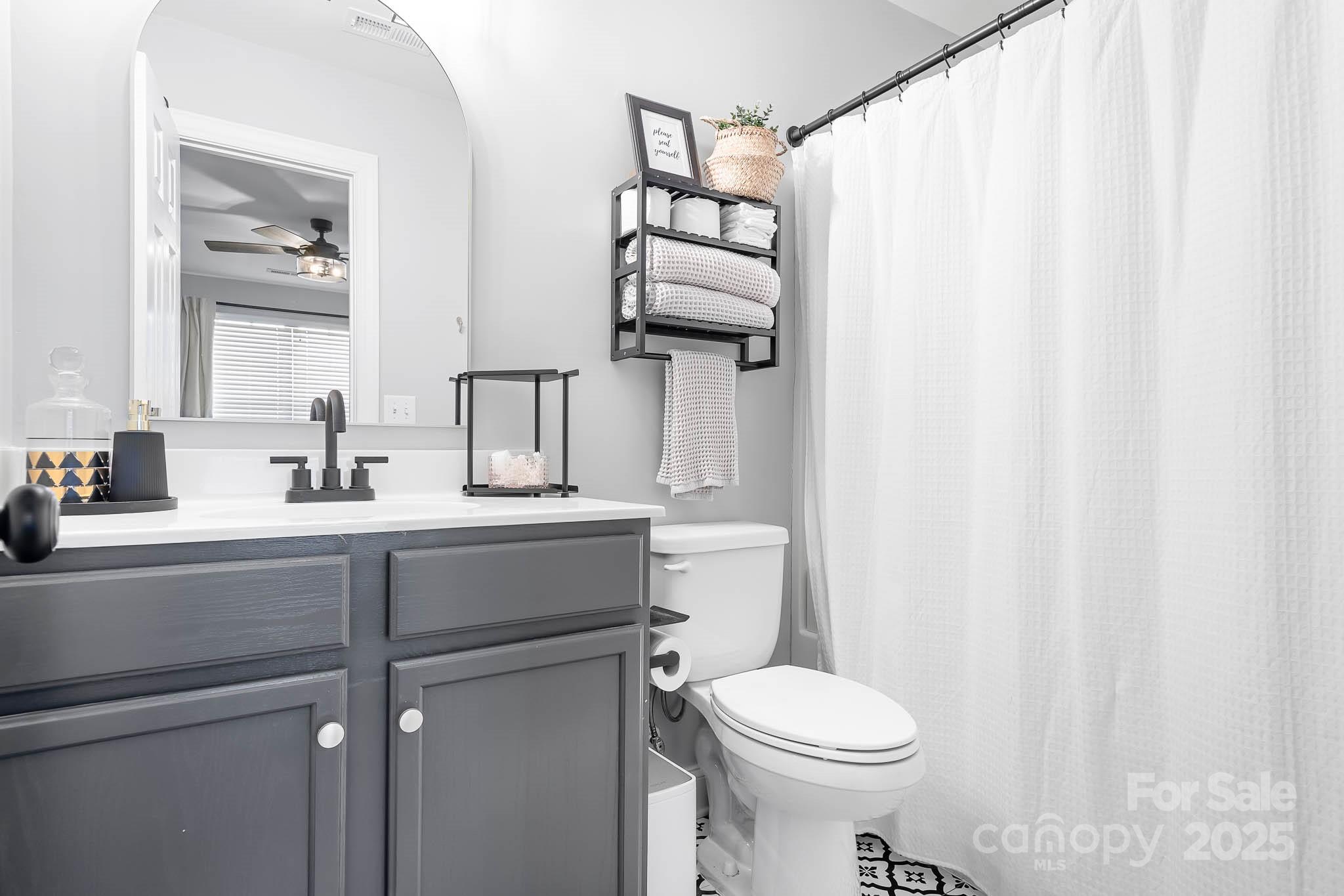 135 High Ridge Road Mooresville, NC 28117 - Photo 18 of 24 a bathroom with a sink a toilet and shower curtain