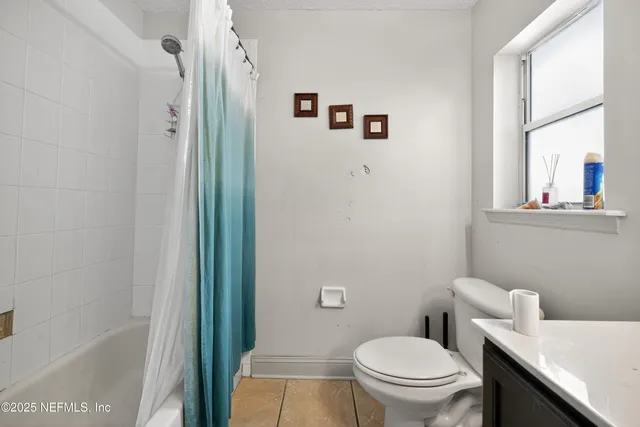a white toilet sitting next to a bathroom sink and a mirror