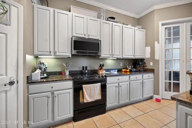 a kitchen with stainless steel appliances granite countertop a sink a stove a microwave and cabinets