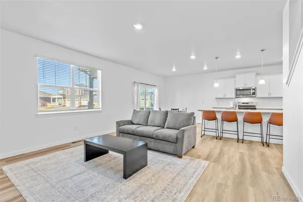 a living room with furniture and a dining table with kitchen view
