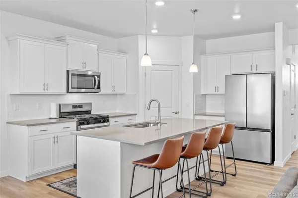 a kitchen with stainless steel appliances a sink stove and refrigerator