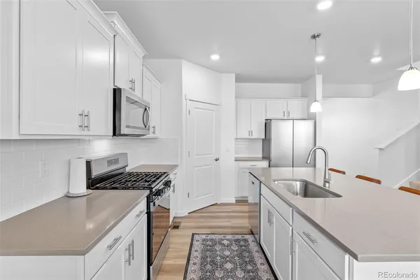 a kitchen with stainless steel appliances granite countertop a stove a sink and a refrigerator