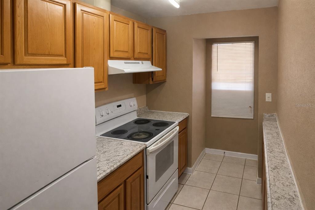2727 West Oak Ridge Road, Unit 2/ BLDG #7 Orlando, FL 32809 - Photo 4 of 13 a kitchen with a stove and a sink