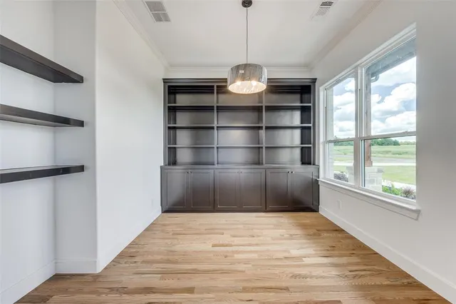 en empty room with windows and ceiling fan