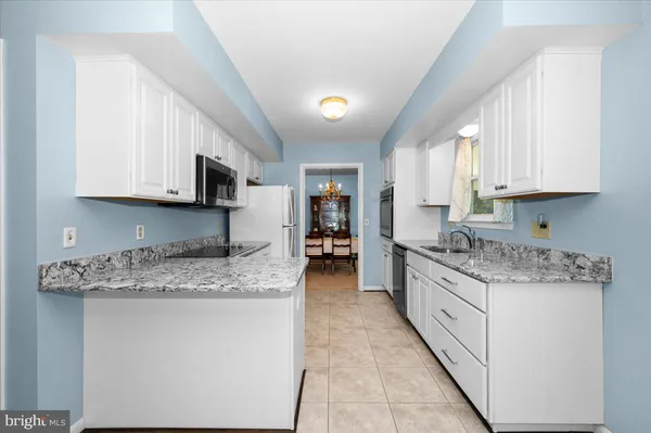 a kitchen with stainless steel appliances granite countertop a stove sink microwave and cabinets