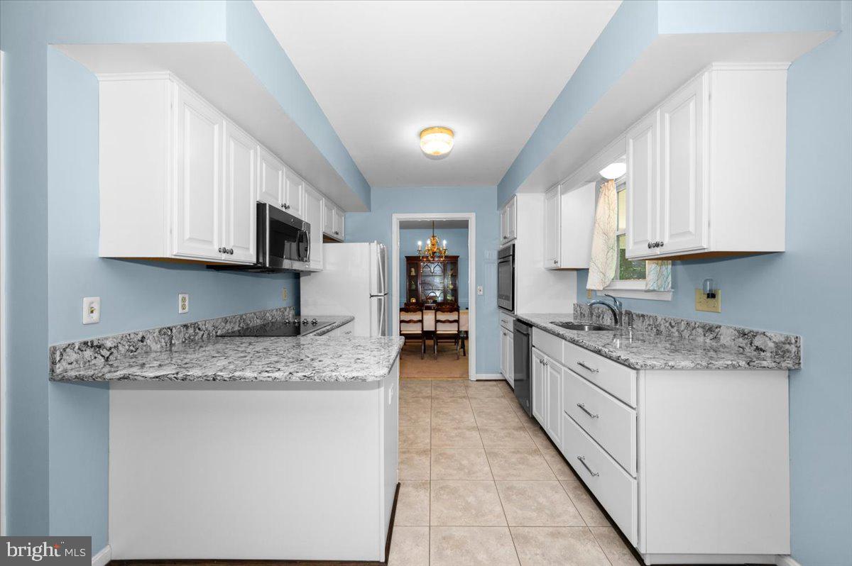 2614 Apple Way Dunkirk, MD 20754 - Photo 9 of 54 a kitchen with stainless steel appliances granite countertop a stove sink microwave and cabinets