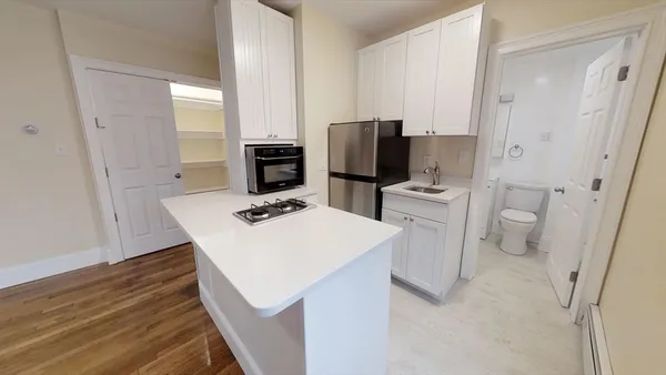 a kitchen with white cabinets and stainless steel appliances