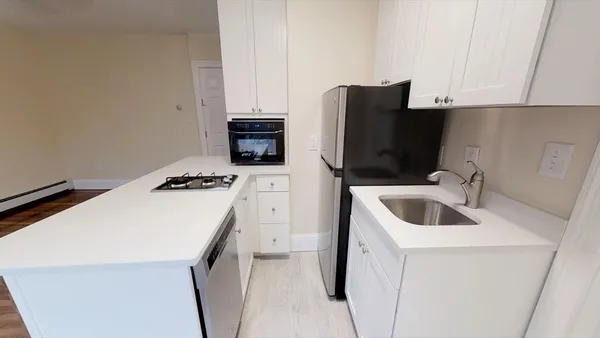 a kitchen with a sink a refrigerator and cabinets