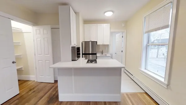 a view of kitchen with sink and refrigerator