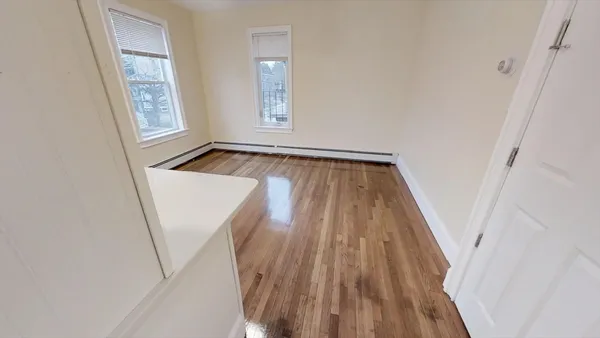 an entryway with wooden floor and windows
