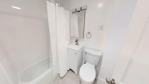 a white toilet sitting next to a bath tub