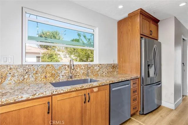 a kitchen with granite countertop a refrigerator and a sink