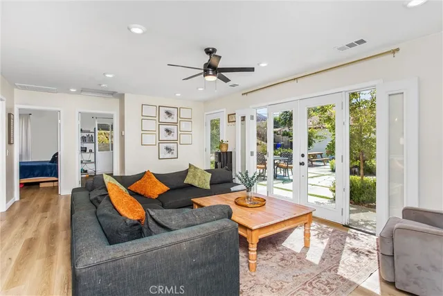 a kitchen with a sink dishwasher stove and white cabinets with wooden floor