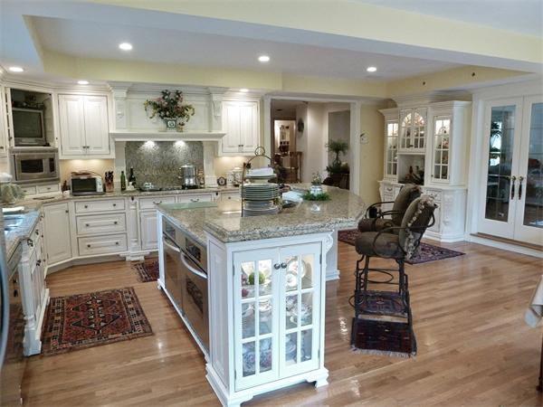 41 Forest Street Sherborn, MA 01770 - Photo 6 of 30 a kitchen with stainless steel appliances granite countertop a stove top oven a sink dishwasher a dining table and chairs with wooden floor