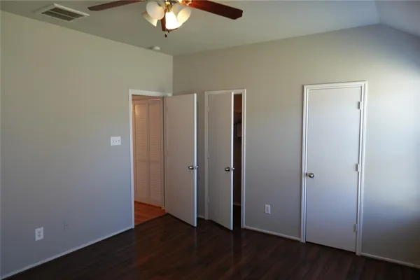 a view of an empty room with wooden floor