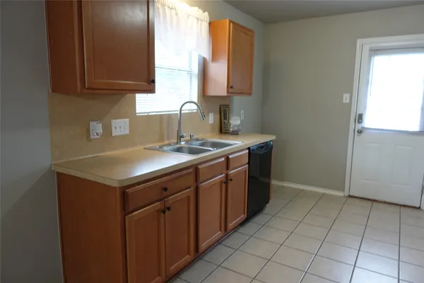 a kitchen with a sink cabinets and a window