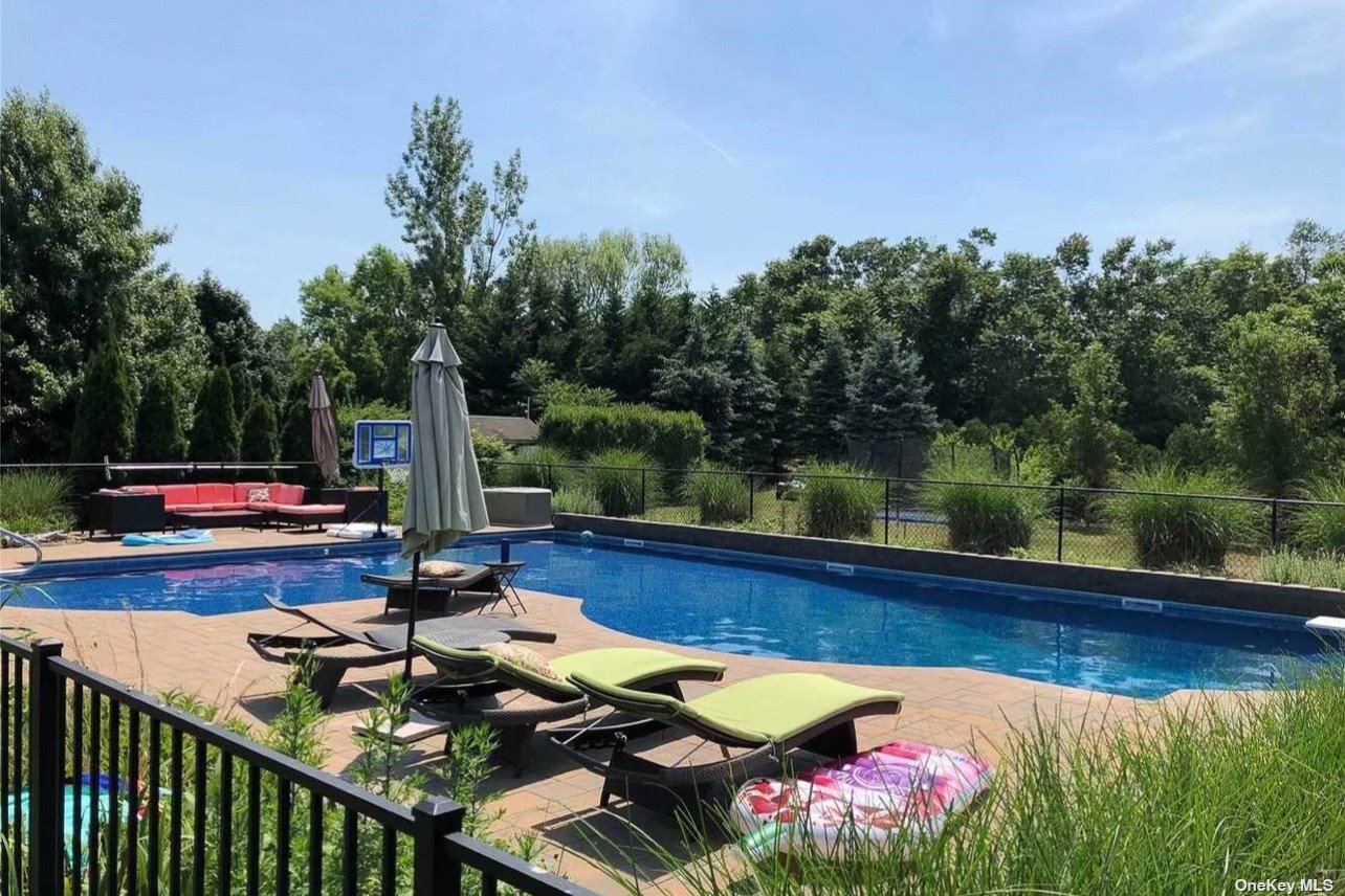 120 Grant Drive Riverhead, NY 11901 - Photo 1 of 1 a view of swimming pool with lounge chair and trees in the background