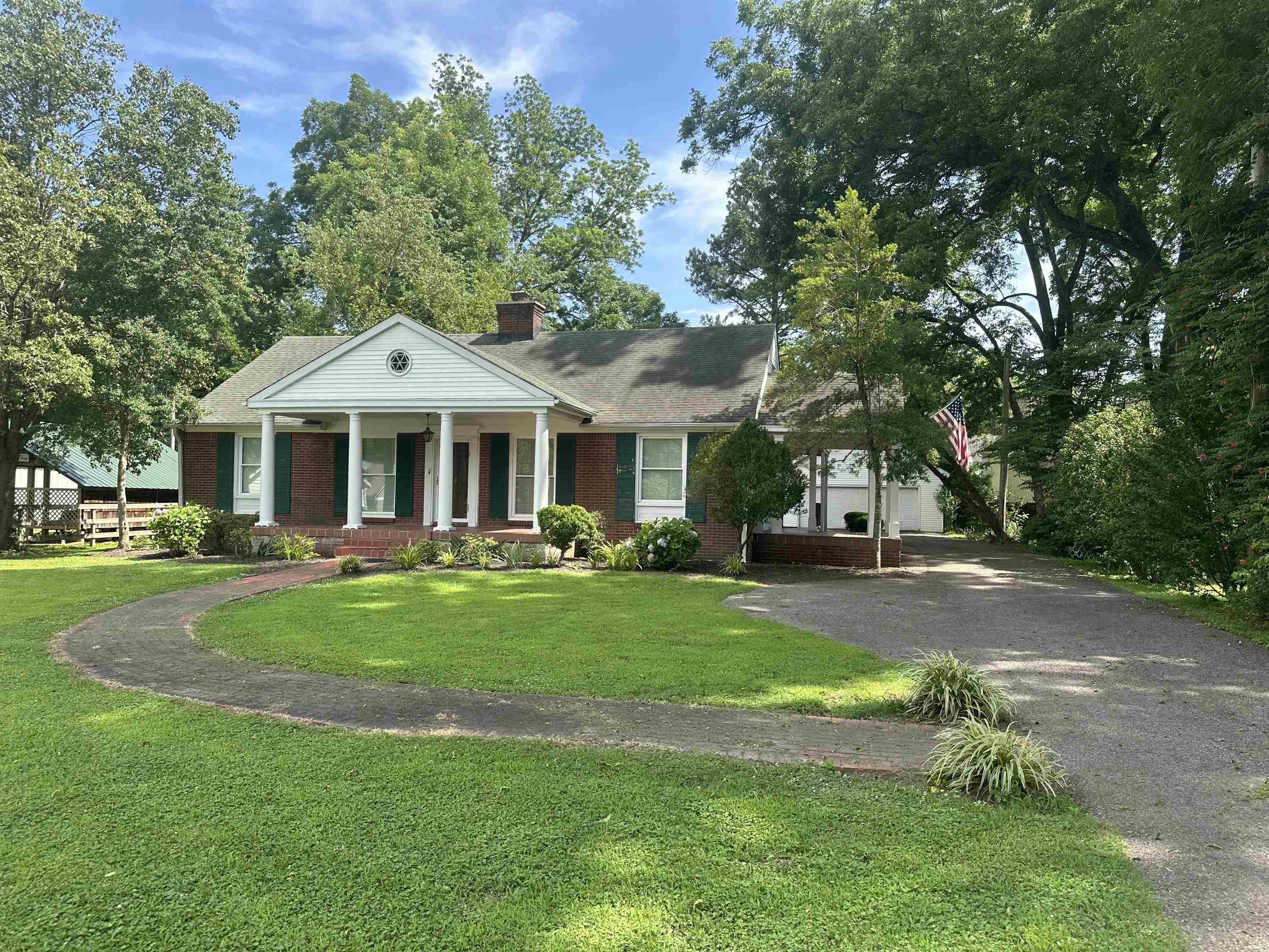 a front view of a house with yard and green space