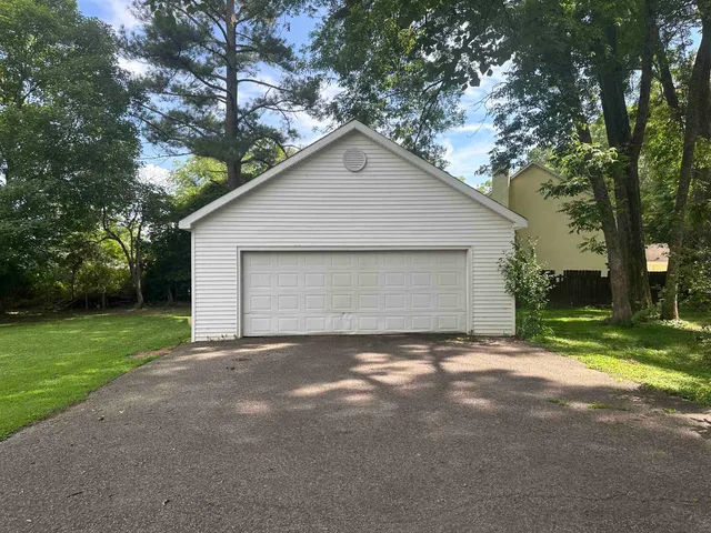 a view of a house with a yard and large tree