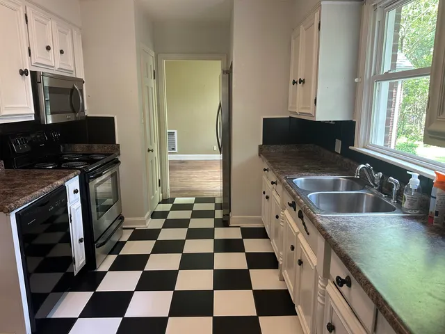 a kitchen with a checkered floor and a stove top oven