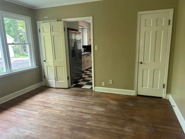 an empty room with closet and a window