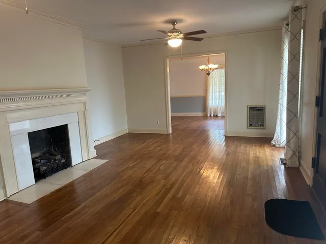 a view of a livingroom with wooden floor and a fireplace