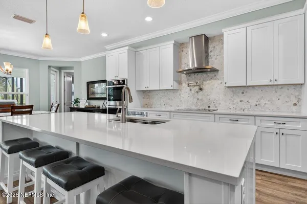a large kitchen with stainless steel appliances kitchen island a large counter top and a wooden floors