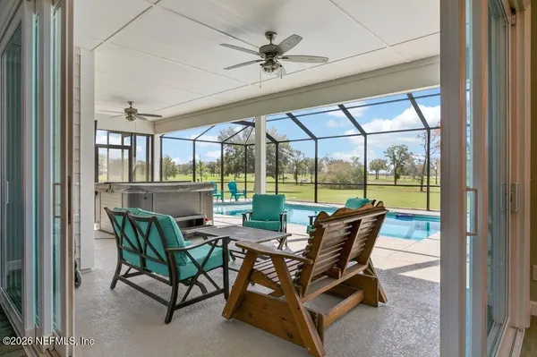 a view of swimming pool with outdoor seating and trees in the background