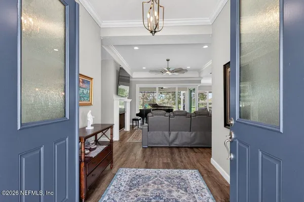 a living room with furniture large window and wooden floor