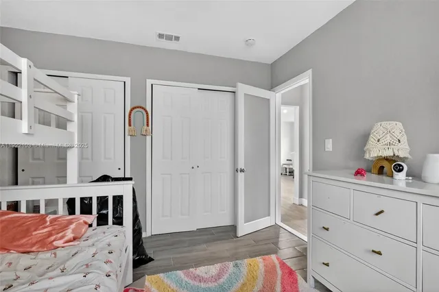 a view of a bedroom with baby crib and lounge chair