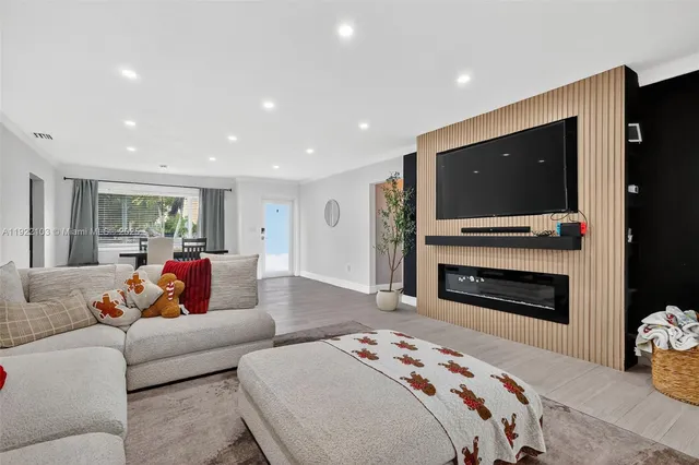 a living room with furniture a fireplace and a flat screen tv