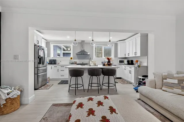 a living room with stainless steel appliances kitchen island furniture and a view of kitchen