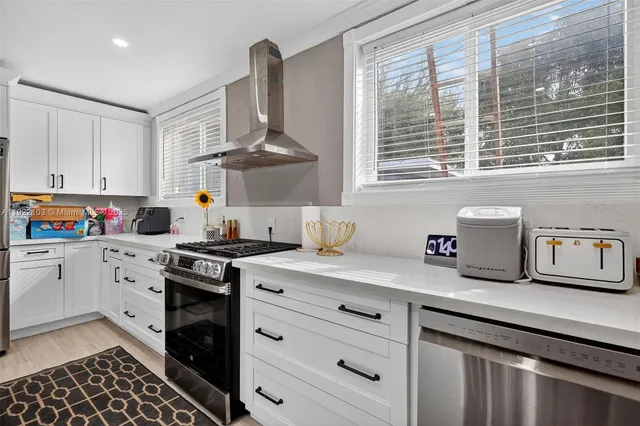 a kitchen with stainless steel appliances granite countertop a sink stove and cabinets