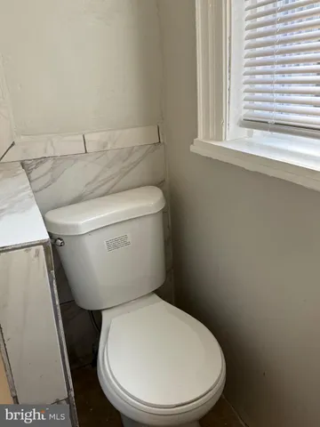a white toilet sitting next to a window