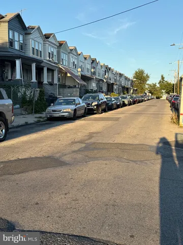 a front view of a building with cars parked