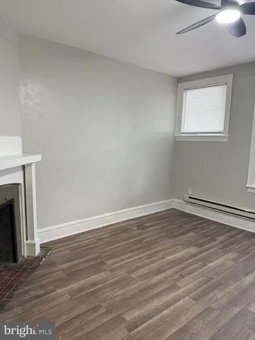 a view of empty room with wooden floor and fireplace