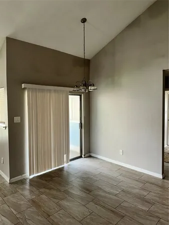 a view of a room with wooden floor and a ceiling fan