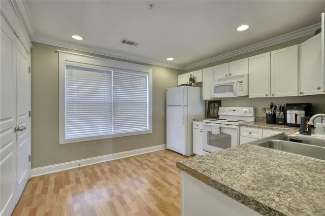 a kitchen with stainless steel appliances granite countertop a sink refrigerator and cabinets