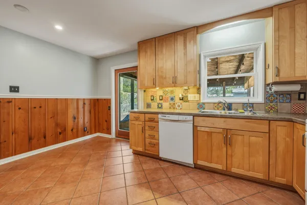 a kitchen with a stove a refrigerator and white cabinets