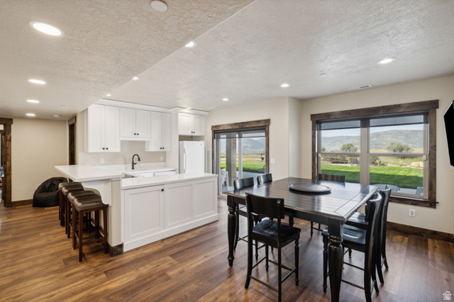 6117 North Rocky Ridge Road Peoa, UT 84061 - Photo 67 of 82 Open-concept kitchen and dining area featuring white cabinetry, light-toned countertops, and wood-finish flooring