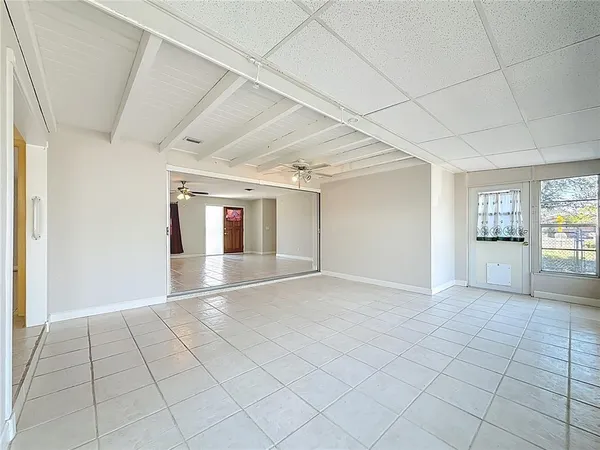 a view of an empty room with window and wooden floor