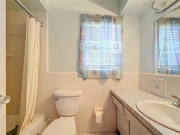 a bathroom with a sink toilet and window