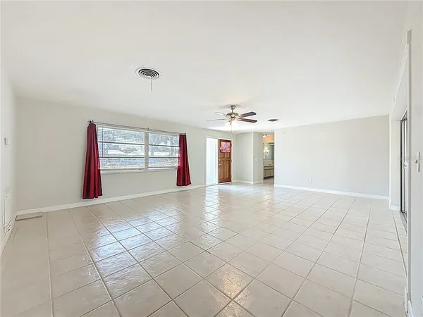 an empty room with windows and fireplace