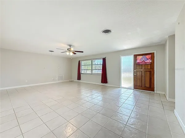 an empty room with windows and fan