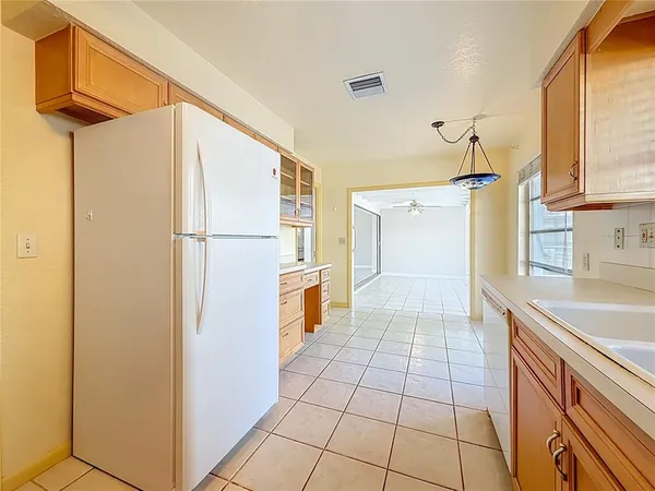 a kitchen with a refrigerator a stove top oven and cabinets